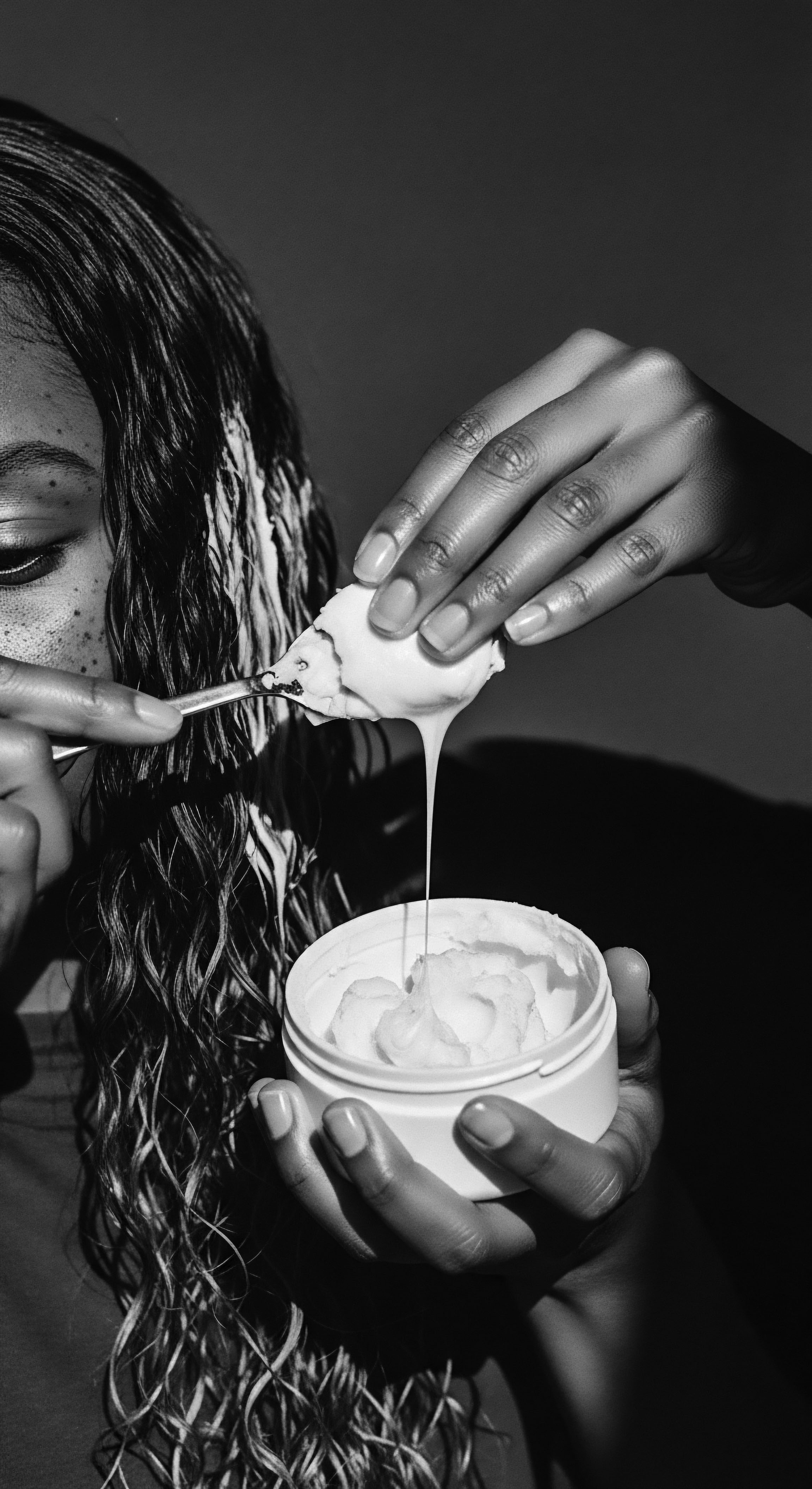 Applying Hydrating Hair Mask to Wet High Porosity Coils for Curl Definition This striking study in chiaroscuro reveals a commitment to scalp health and showcases the application of a nourishing hair mask. The emphasis lies on enriching high porosity coils while fostering sebaceous balance, revealing the timeless beauty of textured hair forms, thus honoring ancestral care.