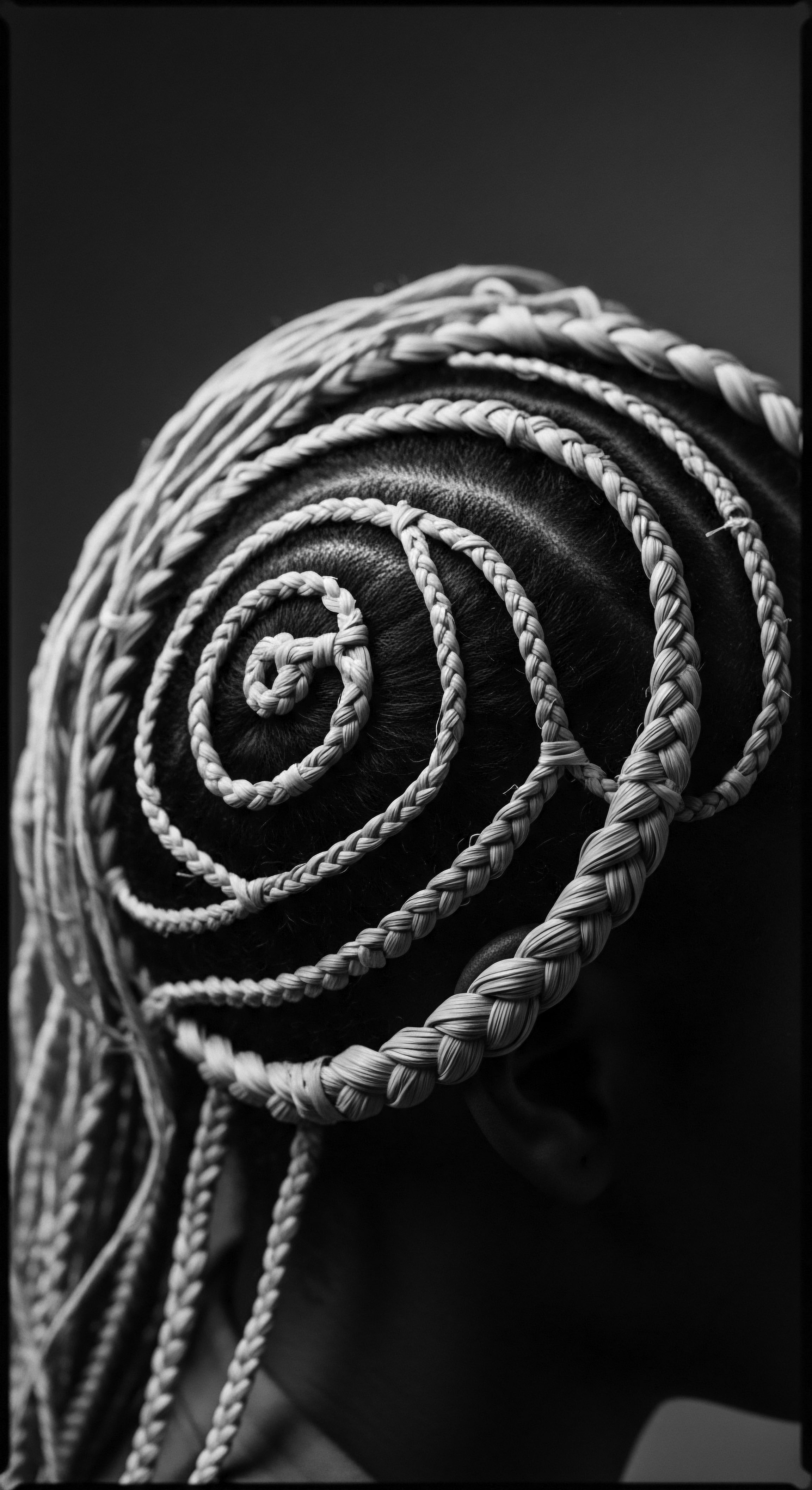 Black and White Image of Crown Braid Hairstyle on Textured Hair Spiral braided crown hairstyle, a striking black and white image highlighting the intricate design and texture on the person's hair. This evokes ancestral heritage, the expression of cultural identity with the light accentuating the artistic and holistic approaches in textured hair traditions.
