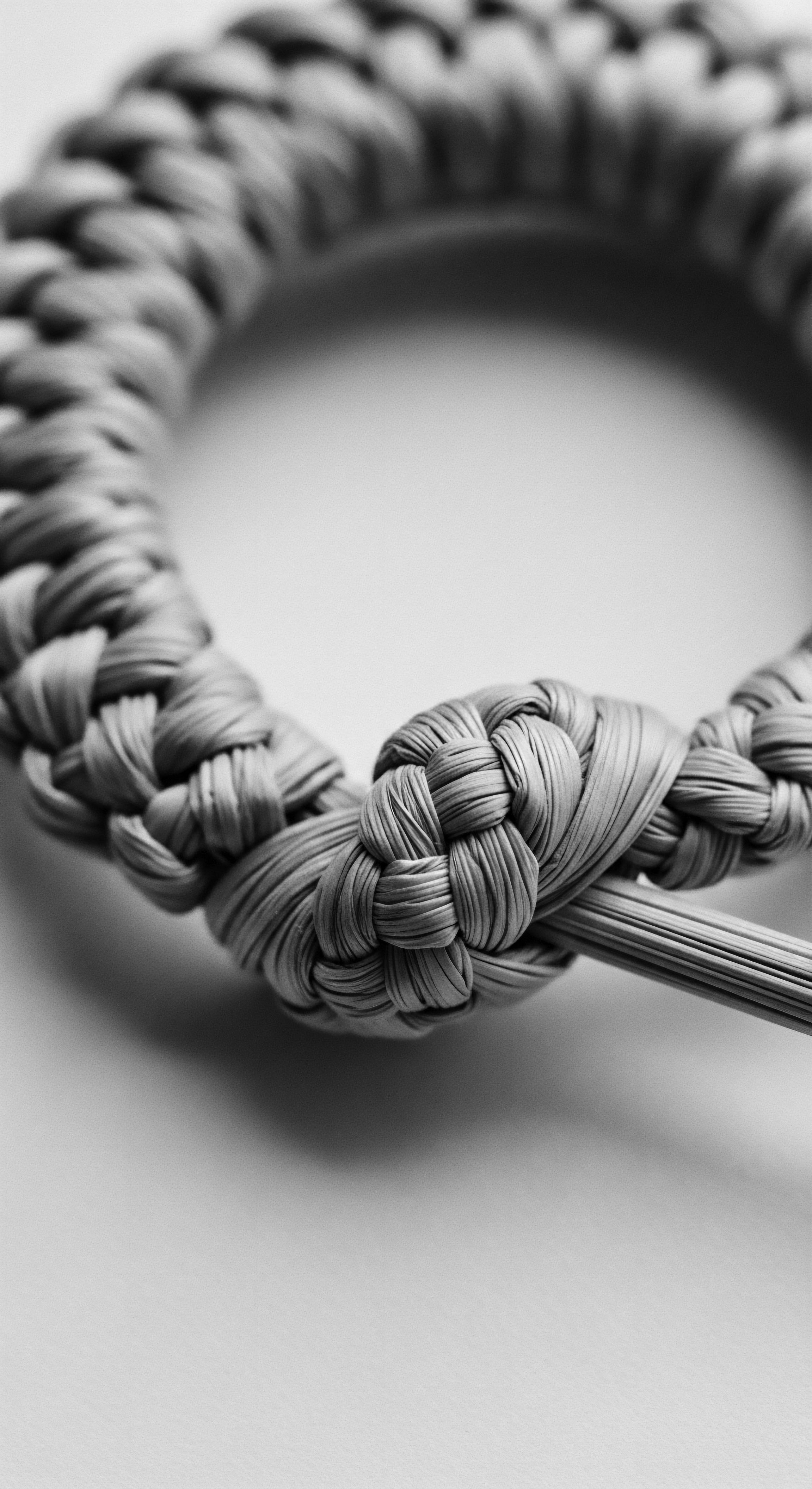 Braided Fiber Knot Showing Intricate Pattern and Textural Complexity Detailed black and white fiber braid photograph brings into focus themes of resilience, heritage, and artistic expression, evoking the complex cultural connections of braiding, emphasizing ancestral traditions while showcasing intricate pattern formation relevant to natural textured formation and styling techniques.