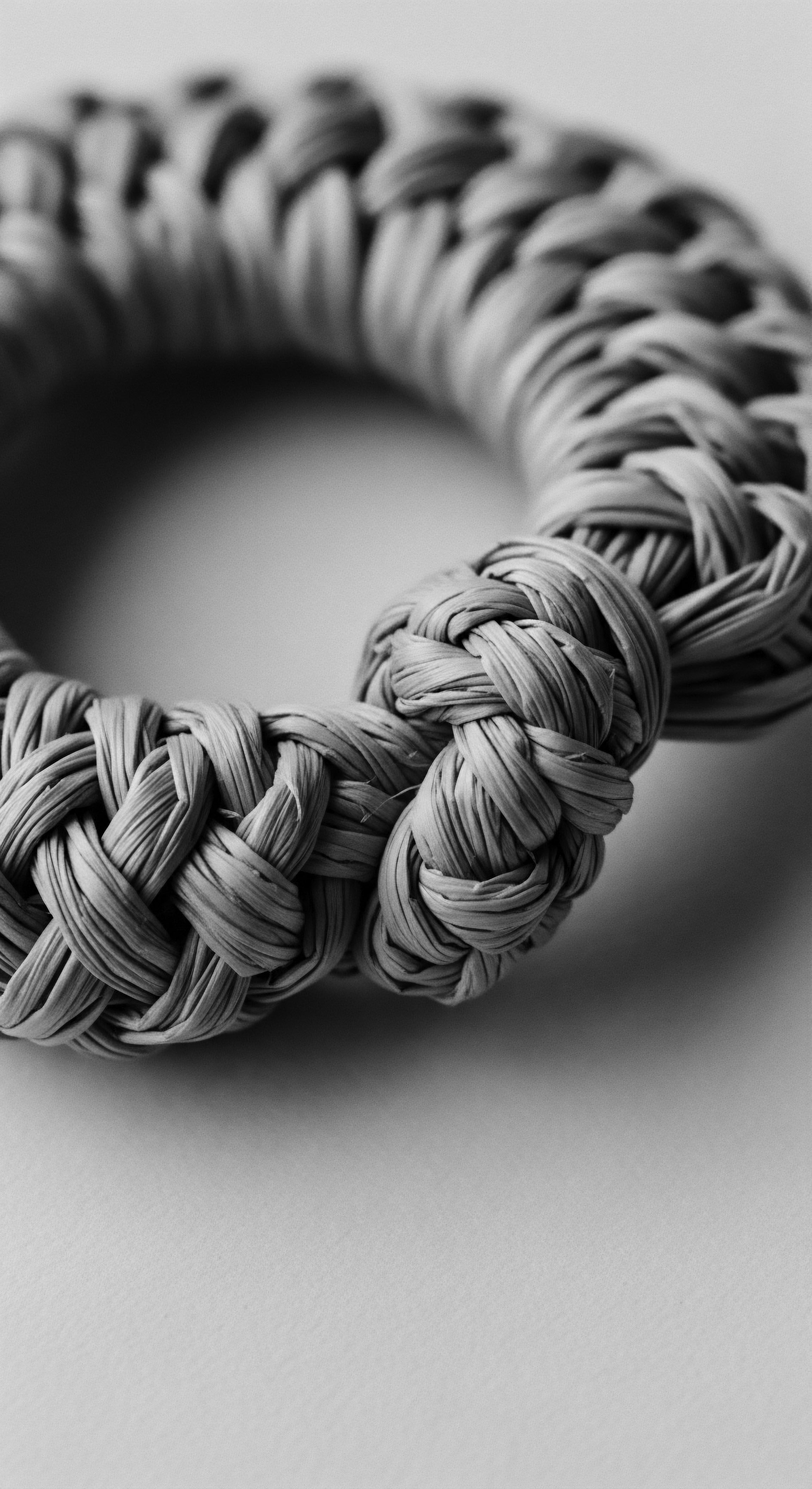 Braided Raffia Cord Ring Exploring Textural Knot Work Artistry The monochromatic woven raffia ring highlights the artistry of braiding traditions, reflecting timeless elegance and a connection to natural materials. The image speaks to heritage, sustainable practices, and the enduring beauty found in simple, organic forms, while honoring holistic traditions and expressive identity.