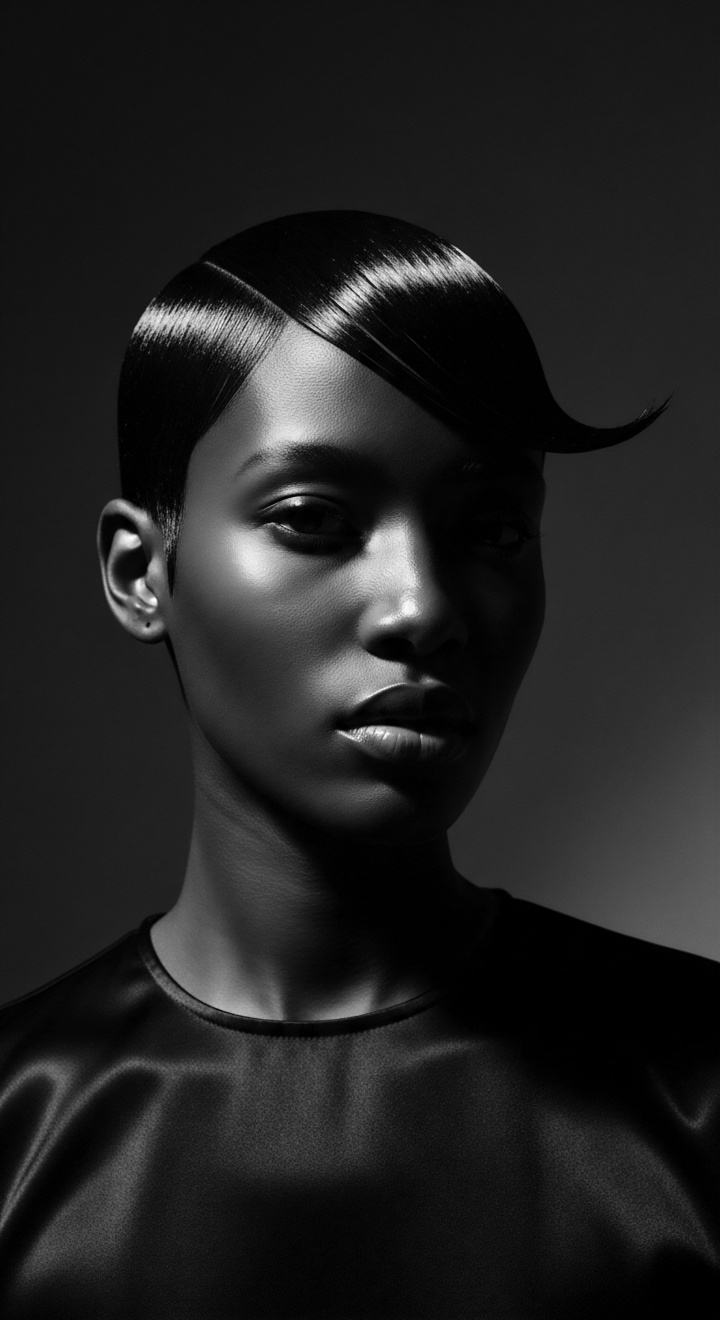 Dramatic Portrait of African Woman with Sculpted Ebon Afro Hairdo This arresting black and white image showcases the beauty of African hair styled into smooth, sculpted waves, reflecting deep cultural heritage and personal expression. The strategic use of light accentuates the hair's texture, mirroring the blend of holistic wellness and elevated styling found in Black hair traditions.