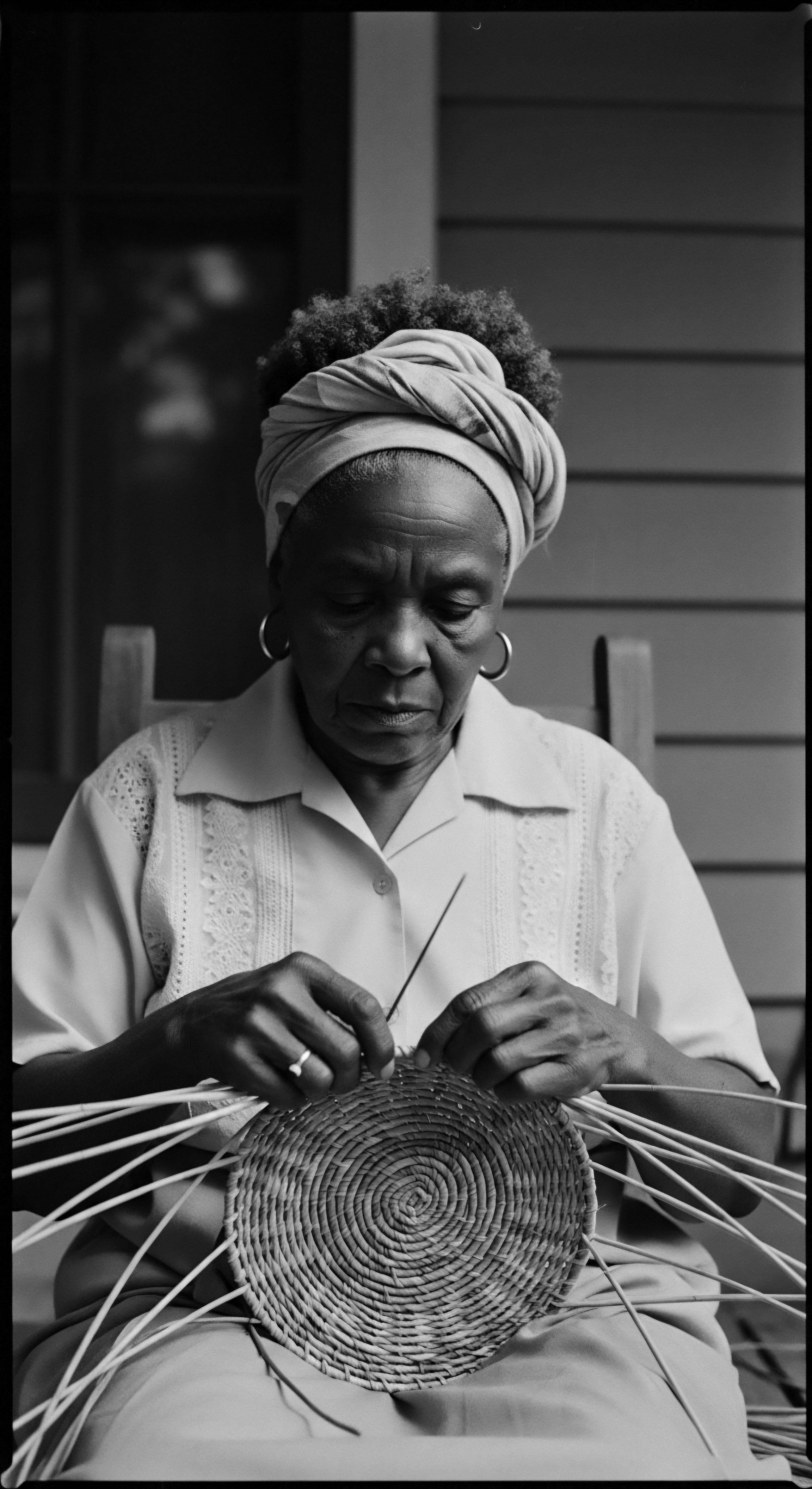 Elderly Black Woman Masterfully Weaving Traditional Basketry with Natural Textured Hair Deep in concentration, the matriarch's hands dance across the basketry, a connection to heritage and an embodiment of holistic artistry. The image is a testament to resilience and celebrates the beauty and cultural significance of coiled textured hair and traditional practices.