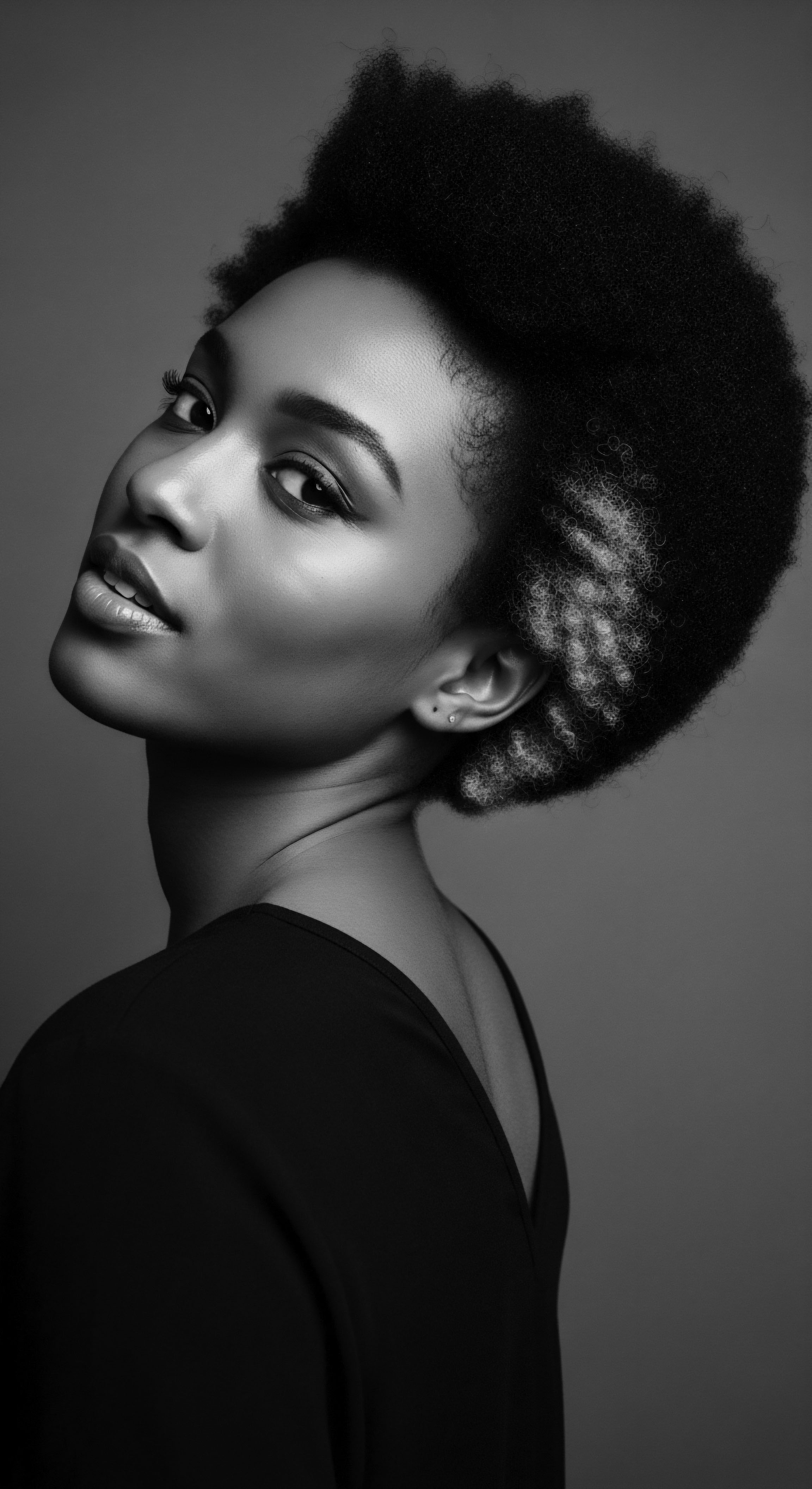 Elegant Black and White Portrait of Woman with Natural Afro Hair This black and white image beautifully captures the essence of natural Afro hair, celebrating its texture and form through carefully crafted braids and a chic, modern aesthetic while reinforcing cultural pride, wellness, and the expressive artistry of Black hairstyles.