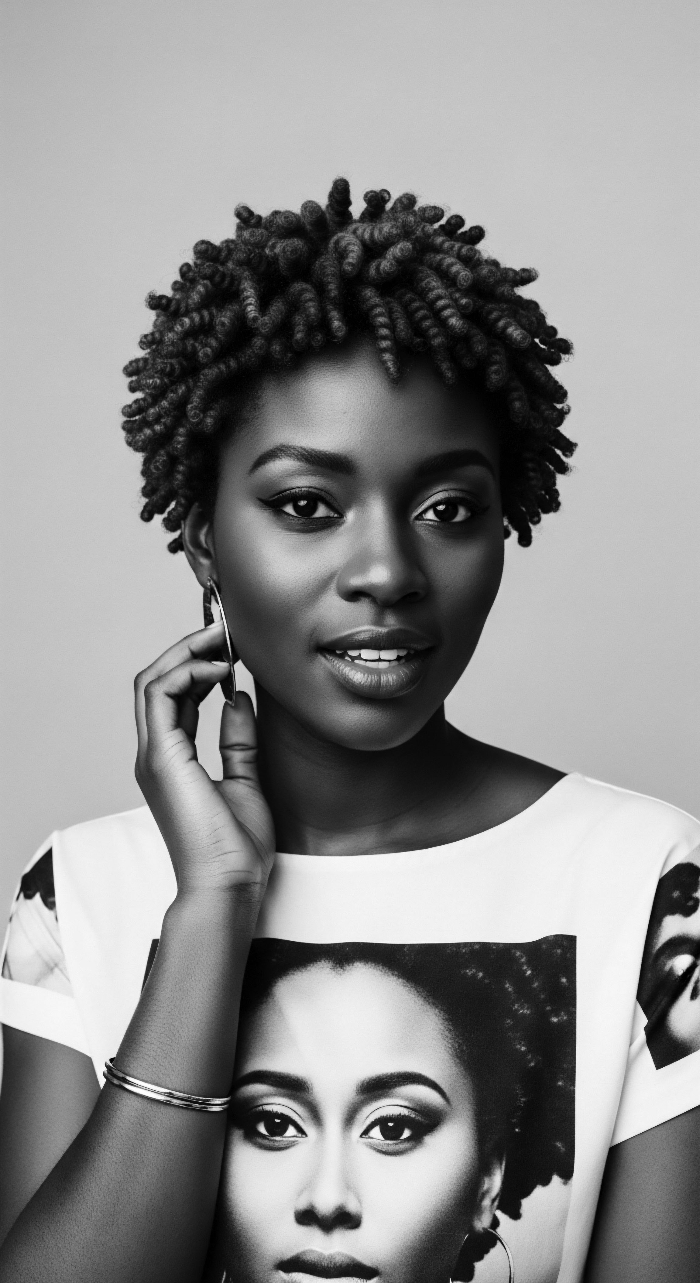 Elegant Black Woman with Coiled Hair Adorned with Hoop Earrings This striking portrait celebrates natural coiled hair, a statement of Black identity and beauty, with modern styling showcasing how ancestral heritage blends seamlessly with contemporary expression, further enhanced by her subtle smile and sophisticated confidence, amplified in Black and White imagery.