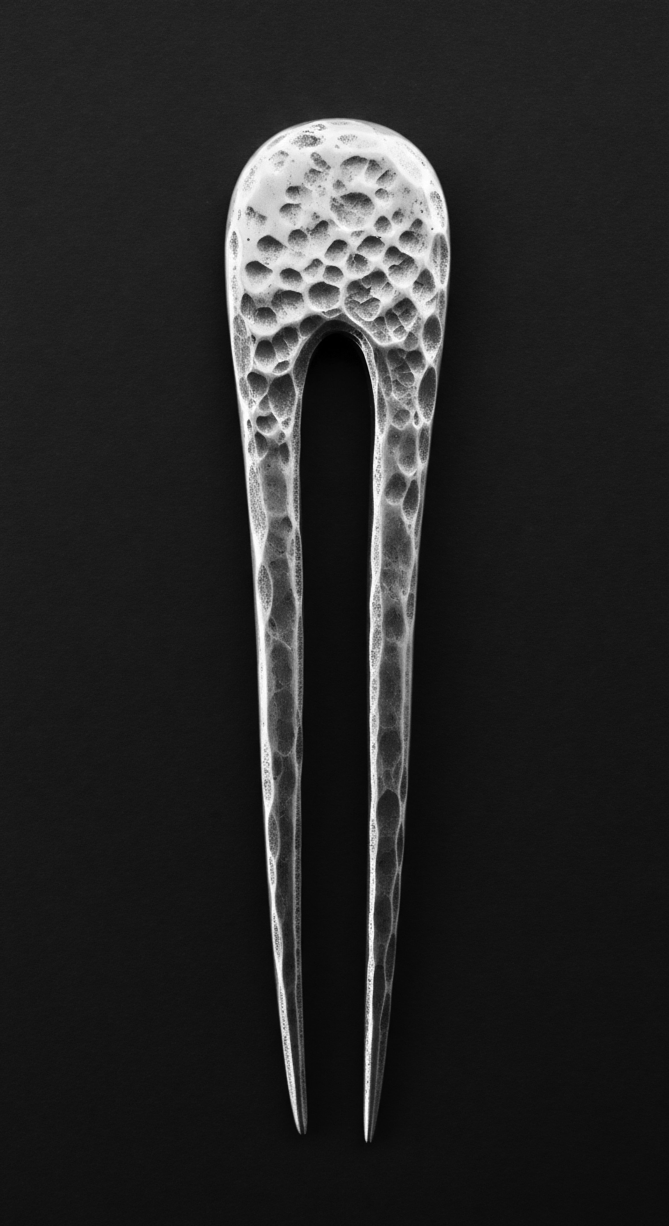 Hammered Silver Hair Pin for Styling Textured Hair Ancestral Adornment The hairpin's textured surface evokes a sense of timelessness, connecting contemporary styling practices with ancestral adornment. This decorative piece symbolizes the rich history of textured hair expression and celebrates heritage through intentional haircare routines, representing a powerful connection to wellness.