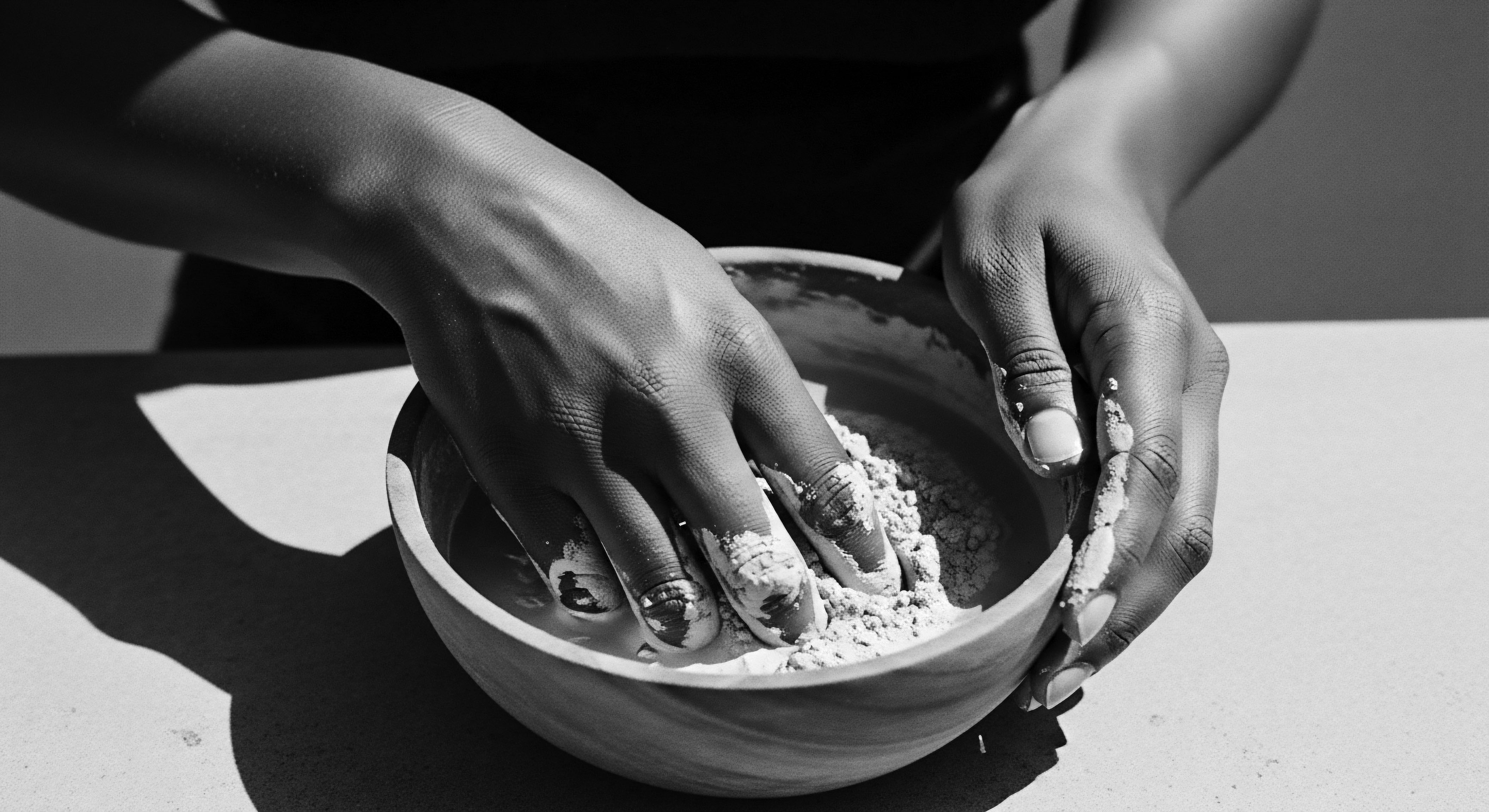 Hands Mixing Natural Clay Mask in Bowl for Holistic Hair Wellness Hands engage in the mindful preparation of a clay mask, a tradition rooted in holistic wellness, showcasing the commitment to natural treatments for nourishing textured hair patterns and promoting scalp health, enhancing ancestral hair care heritage.