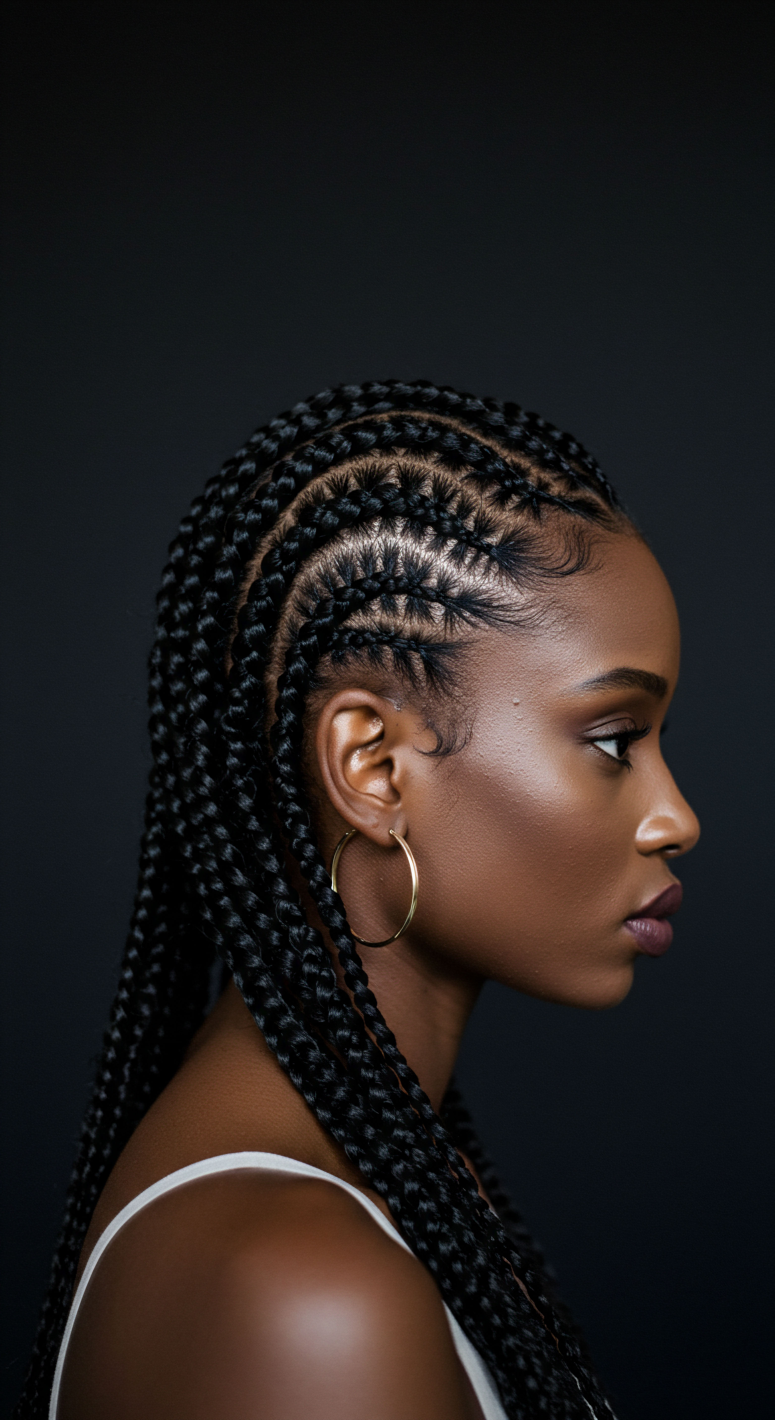 Intricate Cornrow Braids Protective Styling for Coily Textured Hair Heritage Aesthetic This compelling profile portrait beautifully highlights a woman's sophisticated cornrow braids. It's a pinnacle of protective styling for her natural high-density coily texture, showcasing impeccable scalp health, promoting superior moisture retention, and maximizing hair growth. This intricate artistry profoundly celebrates ancestral hair techniques, embodying the vibrant heritage of textured hair care.