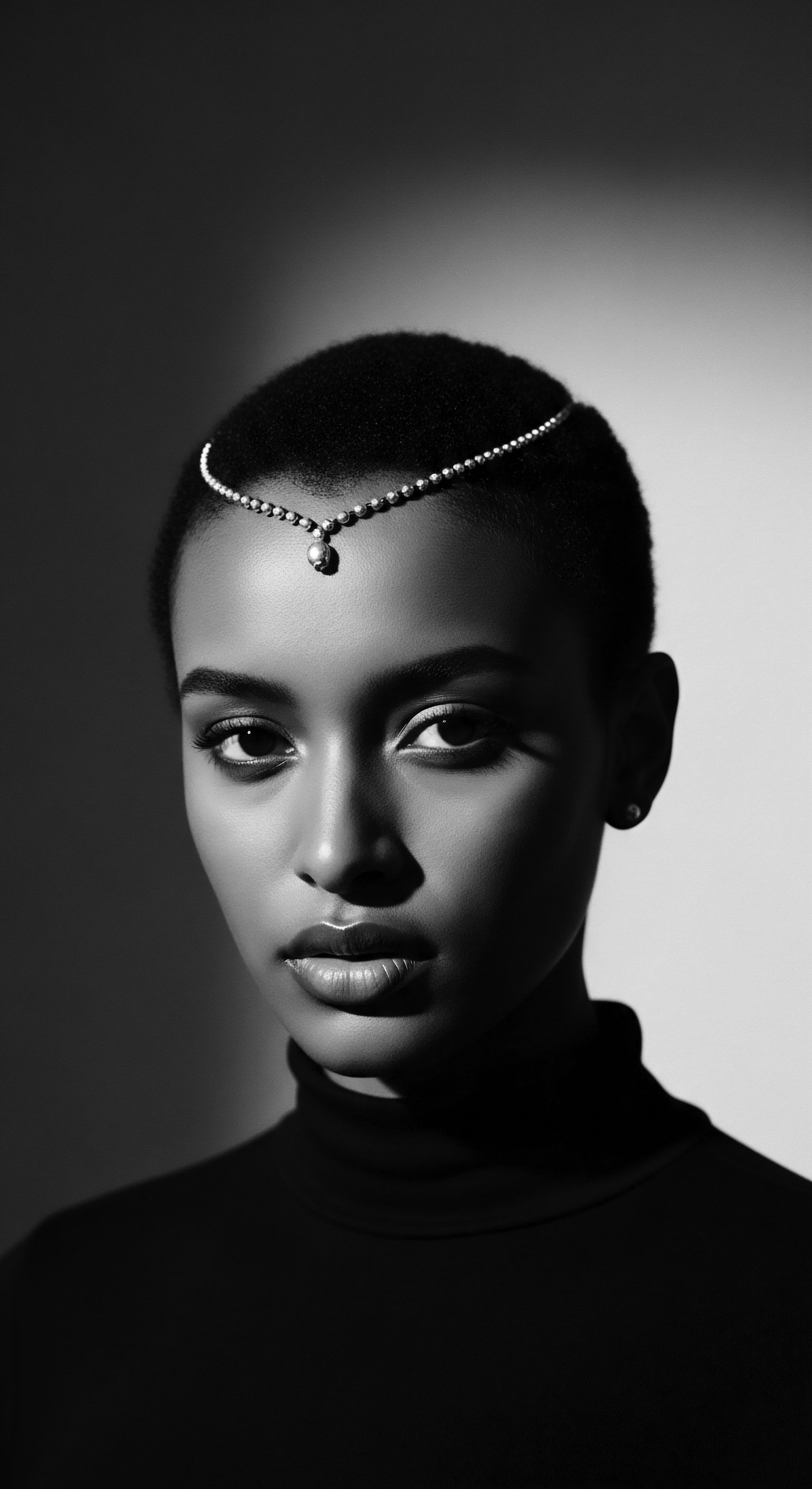 Monochromatic Portrait of Woman with Short Natural Hair and Tiara This monochromatic portrait embodies timeless beauty, showcasing the natural coil of her short coily hairstyle and subtle adornment of tiara, evoking heritage. The chiaroscuro lighting accentuates her features, harmonizing elements of ancestral legacy, confident expression, and modern elegance, representing holistic beauty.