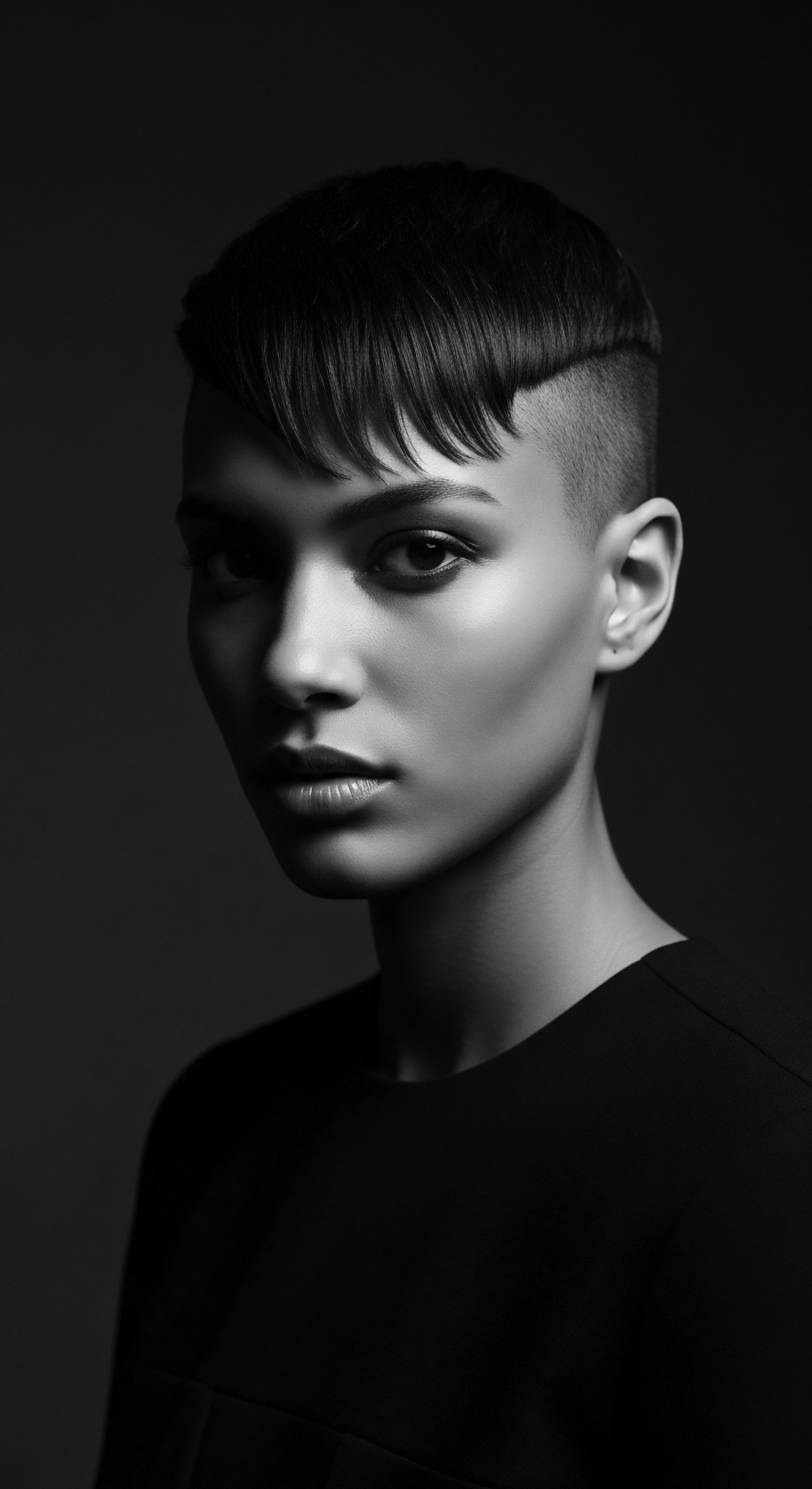 Monochrome Portrait of a Woman with Short Cropped Textured Hair This high-contrast portrait captures a moment of intense self-expression through a unique textured hairstyle, celebrating the beauty and artistry of modern coiffure, the cropped style enhanced by carefully balanced tonalities showcasing the rich detail and expressive freedom within black aesthetics.