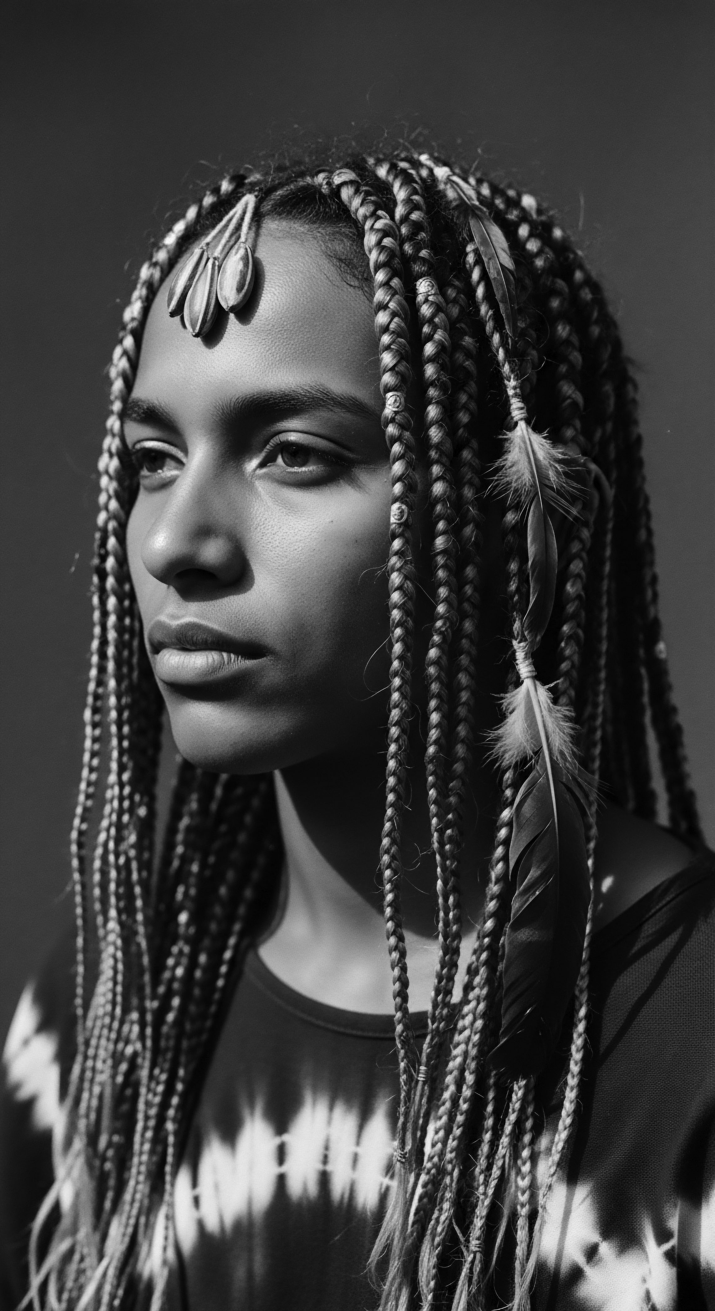 Monochrome Portrait of a Young Woman with Braided Hair and Feathers Through expressive braiding and adornments, the portrait captures the essence of cultural identity and beauty standards. The monochromatic palette accentuates the intricate details of the braids, symbolic of resilience and the enduring legacy of Black hair traditions and holistic hair care practices.