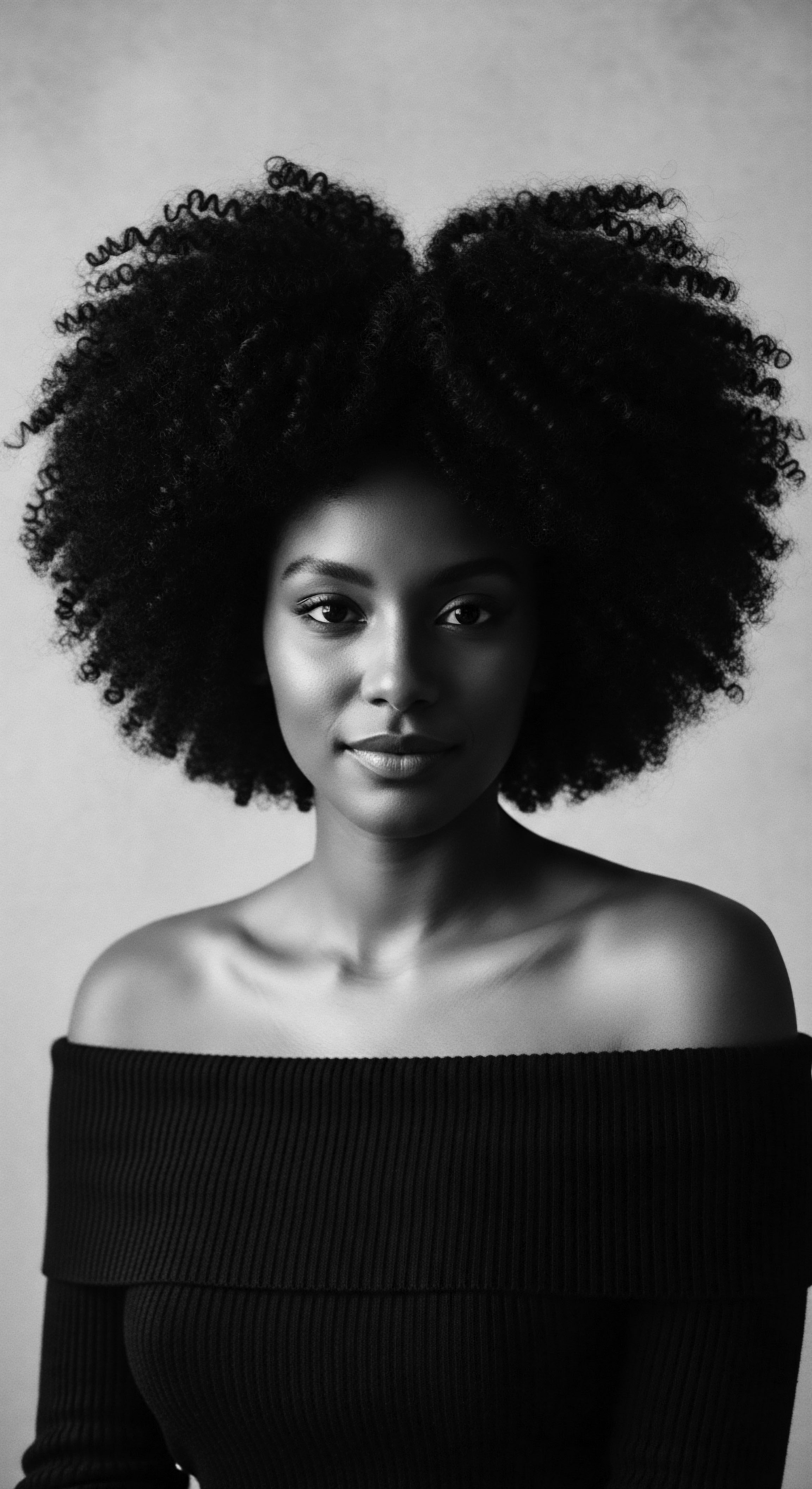 Portrait of Elegant Woman with Afro Textured Hair Against Neutral Backdrop This evocative image celebrates the magnificence of afro textured hair, spotlighting its rich coily pattern and the confident presence of its wearer, encapsulating both ancestral heritage and modern hair aesthetic with elegance that resonates with holistic expressions of beauty.
