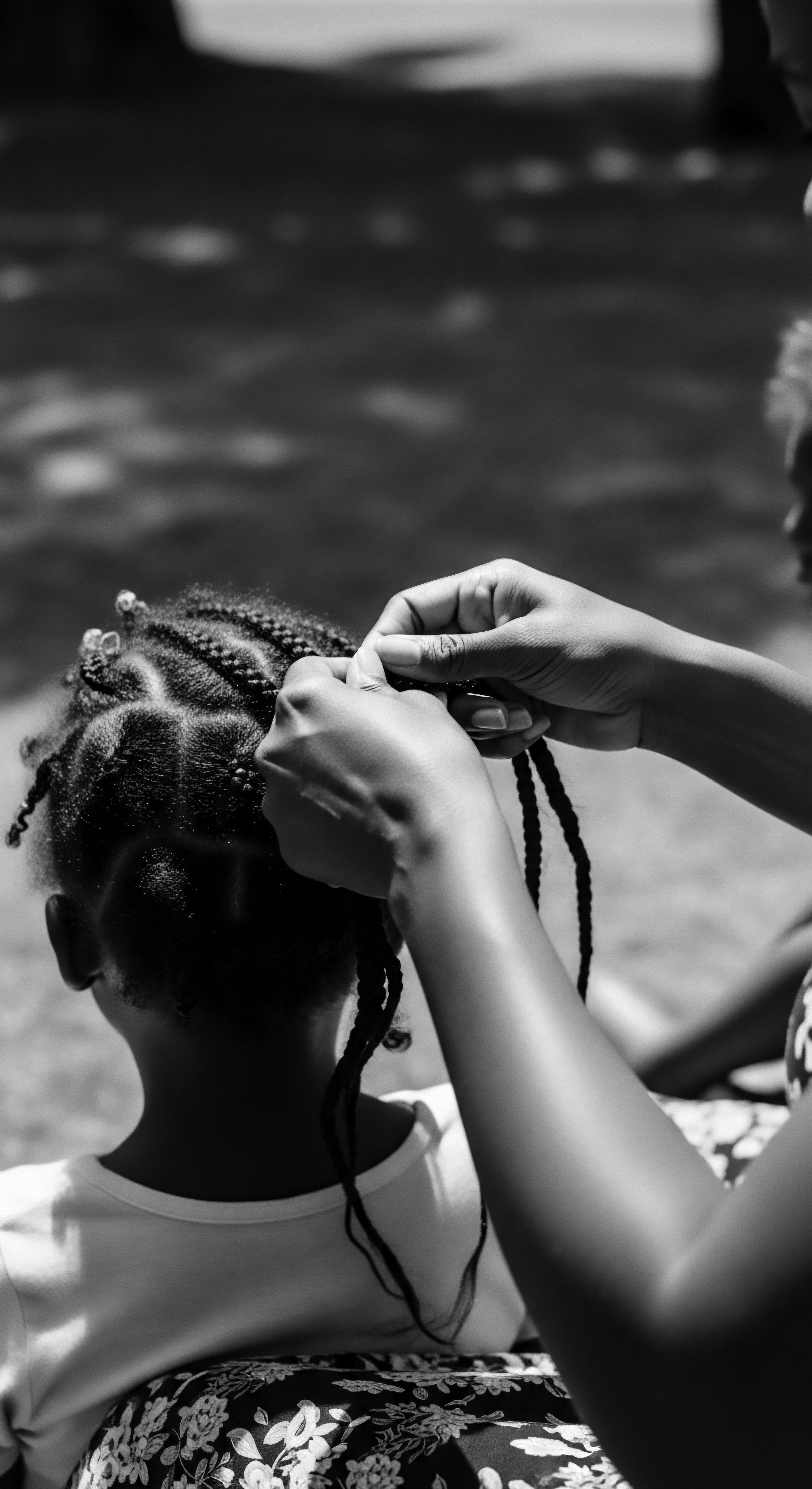 Intricately braiding cornrows, this protective style is a celebration of textured hair's wellness, deeply rooted in African ancestral heritage. Hands deftly manipulate each strand, ensuring longevity, health, and beauty each coil a story of identity and cultural pride.