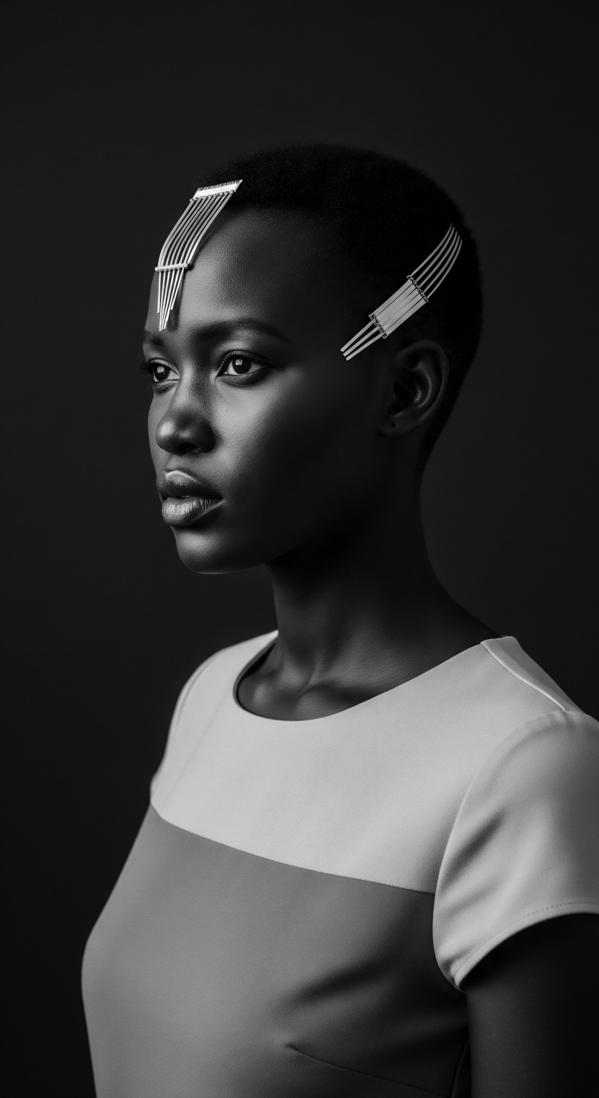 Striking Monochrome Portrait African Woman Short Textured Hair Artistic Adornment The image thoughtfully portrays the woman's distinct elegance and resilience through the interplay of sharp light and darkness across her features and short textured hair. Evoking themes of personal heritage and sophisticated adornment, this artistic rendering celebrates the inherent beauty and cultural significance of short, natural hairstyles.
