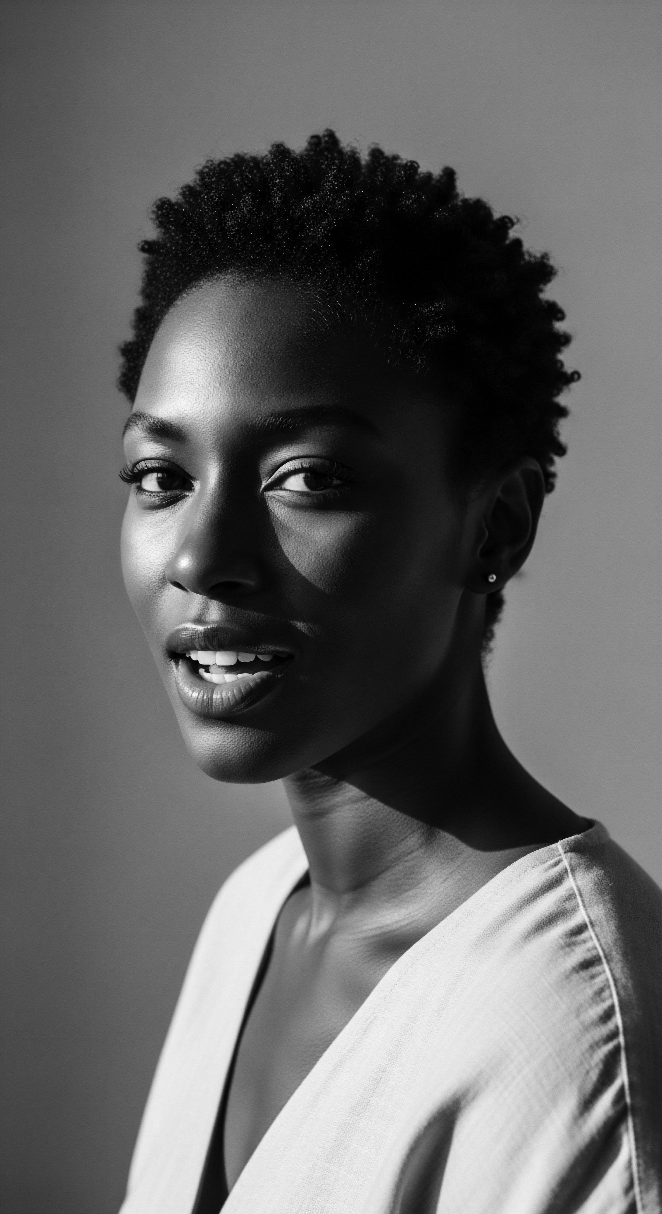 Striking Monochrome Portrait of a Black Woman with Natural Hair Texture The monochrome portrait captures a timeless beauty, celebrating the diverse textures within Black hair traditions light plays across the model's coiled hairstyle, symbolizing strength and natural elegance, while invoking a sense of ancestral pride and affirming identity.