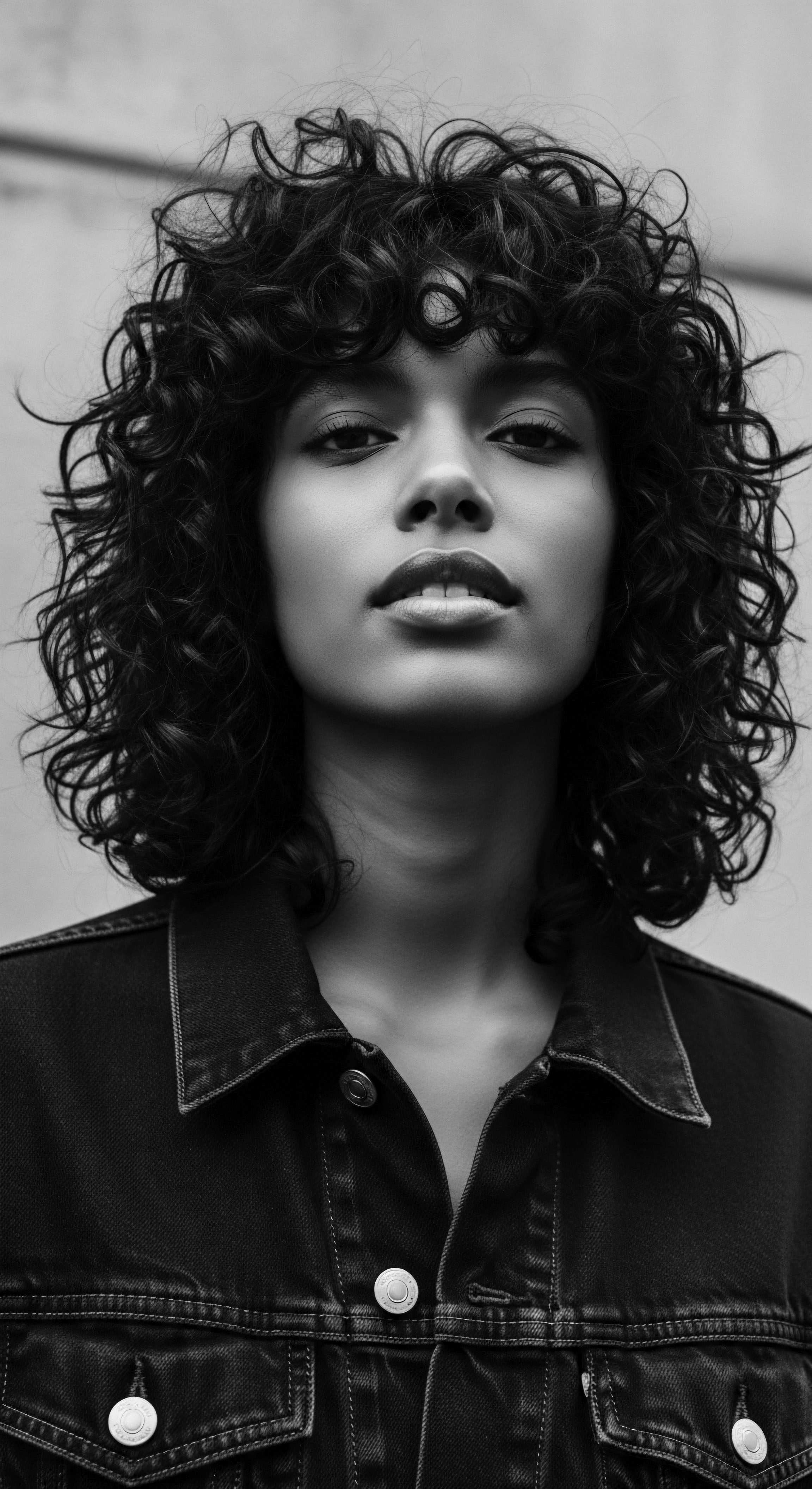 Striking Portrait of a Woman with Dense Coiled Textured Hair This striking portrait honors the inherent beauty of tightly coiled afro-textured hair, a celebration of natural hair amplified by carefully designed studio lighting and sharp monochromatic contrast. The styling and expression are a visual testament to self-acceptance, heritage and empowered self-expression through expressive coil formations.