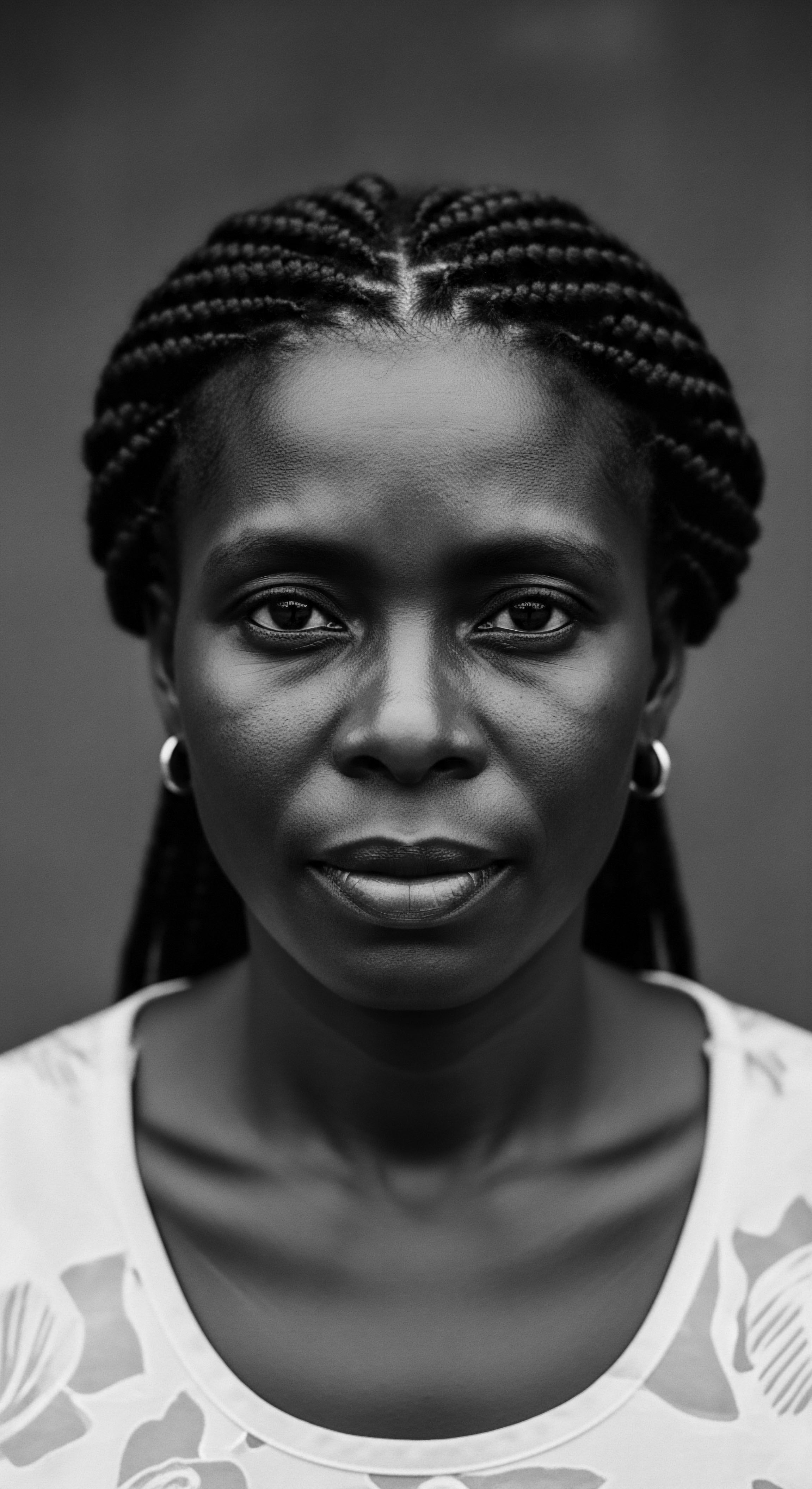Striking Portrait of Black Woman with Braided Hair Style and Earrings This portrait resonates with the timeless beauty of textured hair and its significance in cultural expression, highlighting the intricate details of the cornrow braiding style and the woman's confident gaze, celebrating ancestral heritage through the artful arrangement of her natural hair formation.