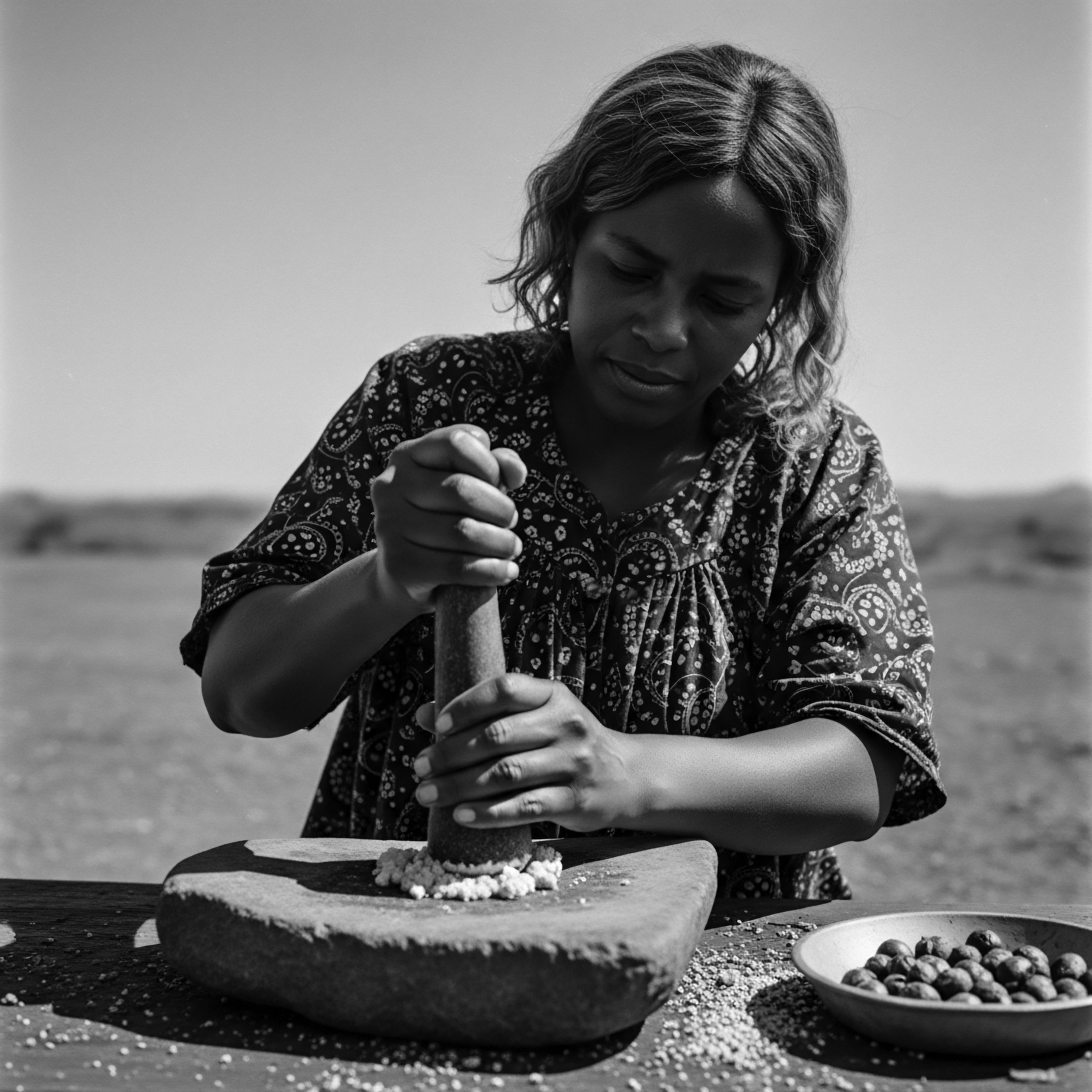 Woman Prepares Traditional Remedy Outdoors Using Stone Mortar and Pestle Preparing natural remedies with ancient tools connects this woman to her ancestral heritage, illustrating the preservation of traditions in textured hair care. The image, highlighting light and shadow, tells a story of resilience, wellness, and timeless beauty practices.